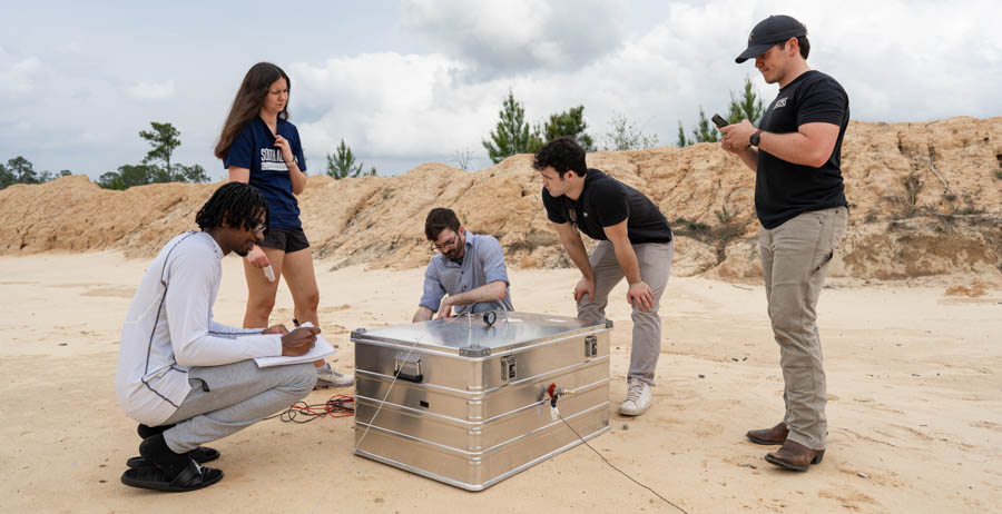 ý students, from left, Devon Edinburgh, Paige Palazzo, Matthew Crump, Reed Turner and Luke Andress run though a series of tests on their senior research project at a firing range north of Mobile. 